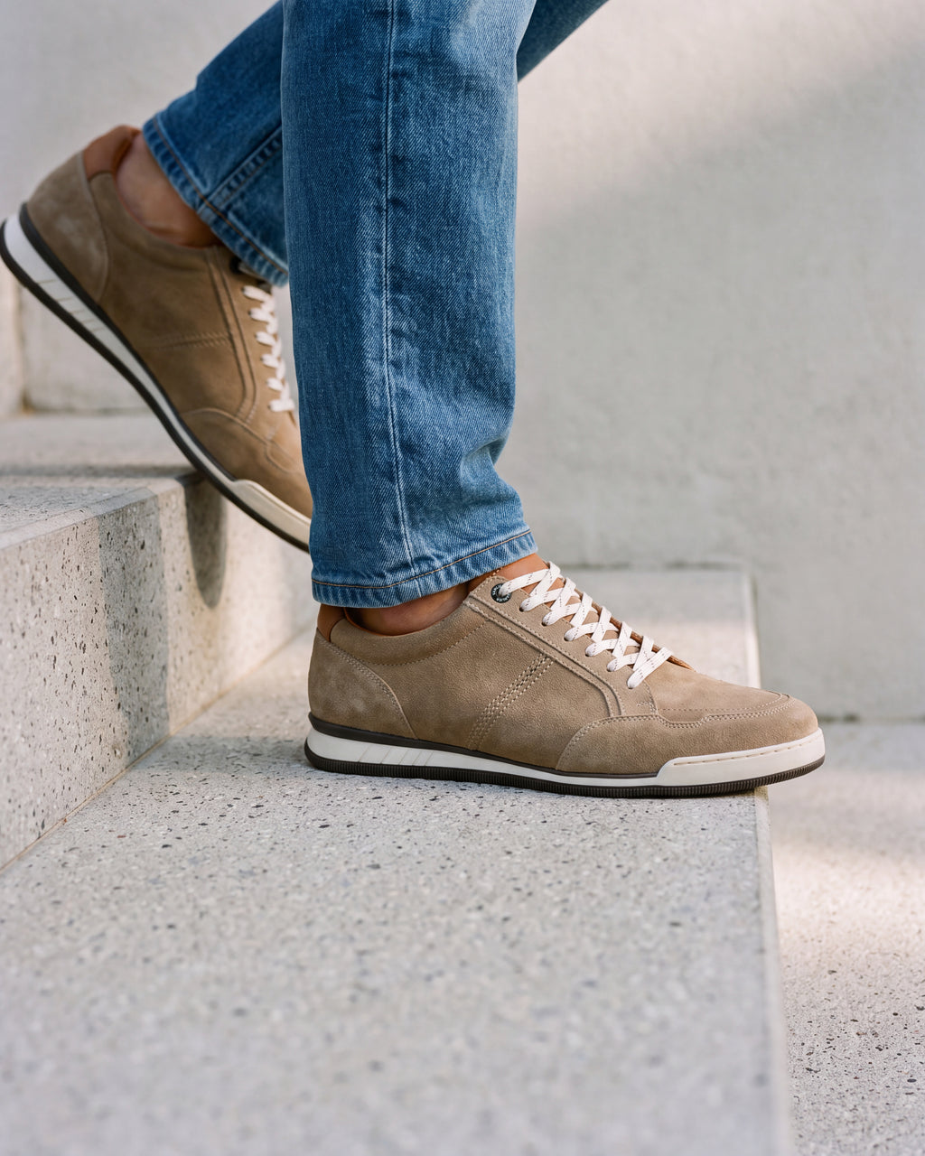 Zand beige suède Magnus sneaker – close-up van het paar in een betonnen atelier