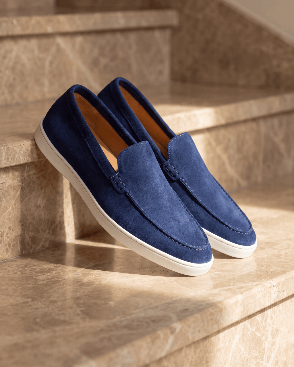 Blauw suède Lugano loafer – het paar op warm marmer