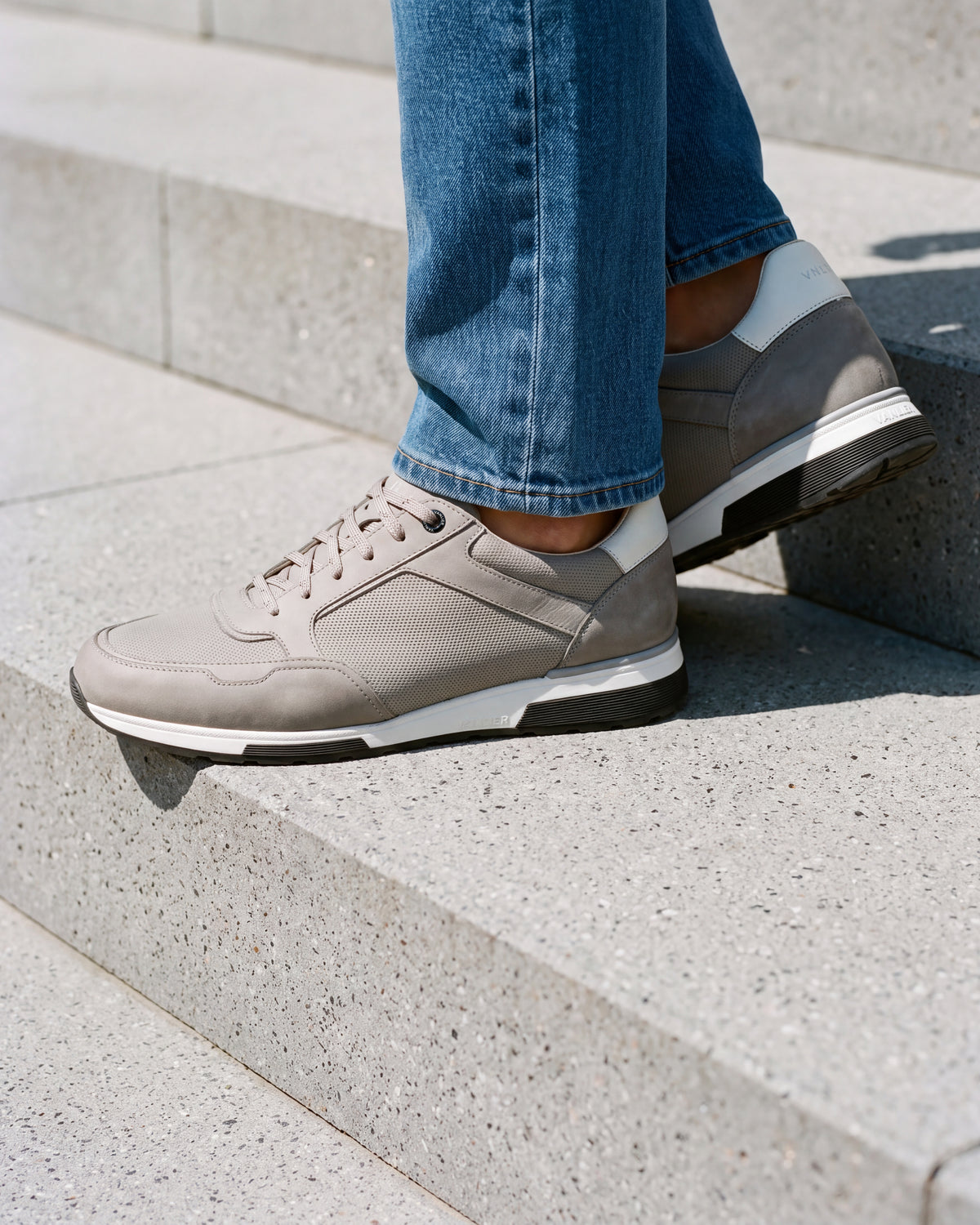 Lichtgrijs nubuck Positano sneaker – close-up van het paar op een betonnen vloer