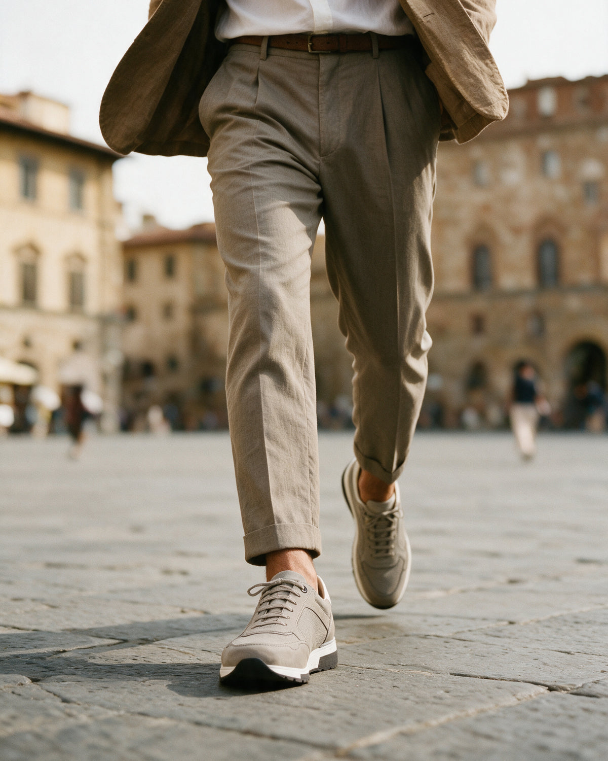 Lichtgrijs nubuck Positano sneaker – lifestyle tijdens het oversteken van het plein