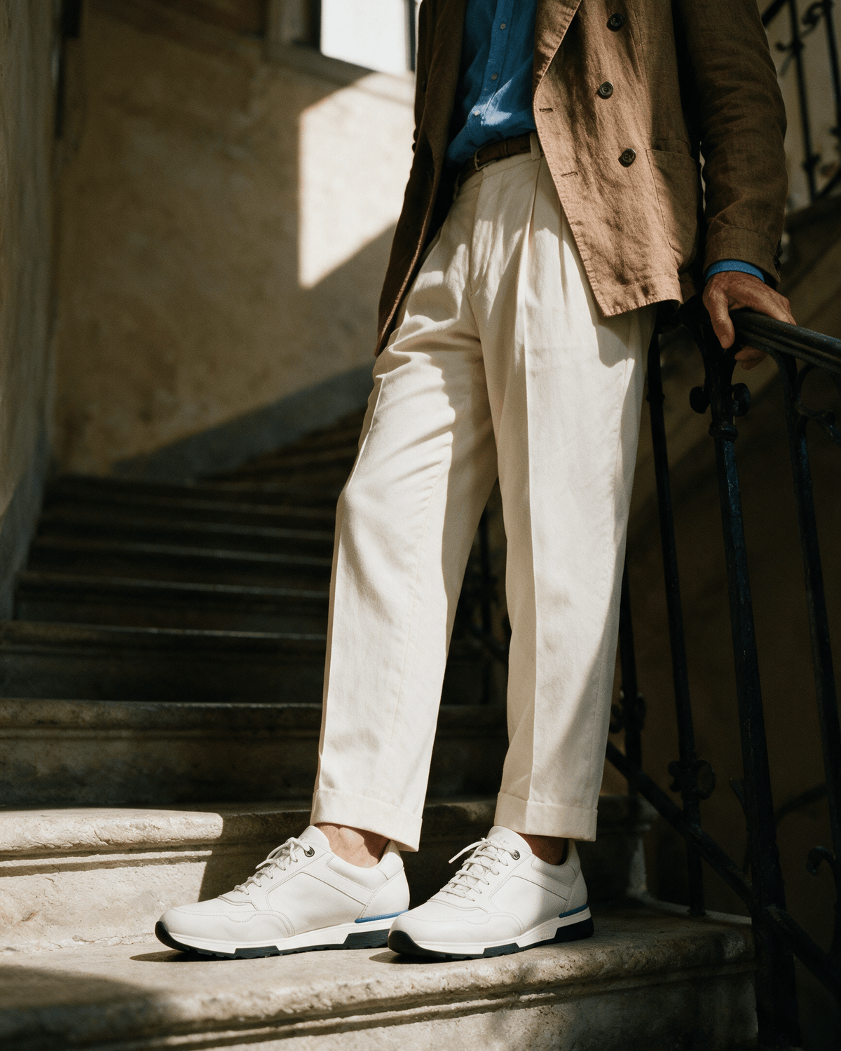 Wit gladleren Positano sneaker – gedragen, pauzerend op een trap