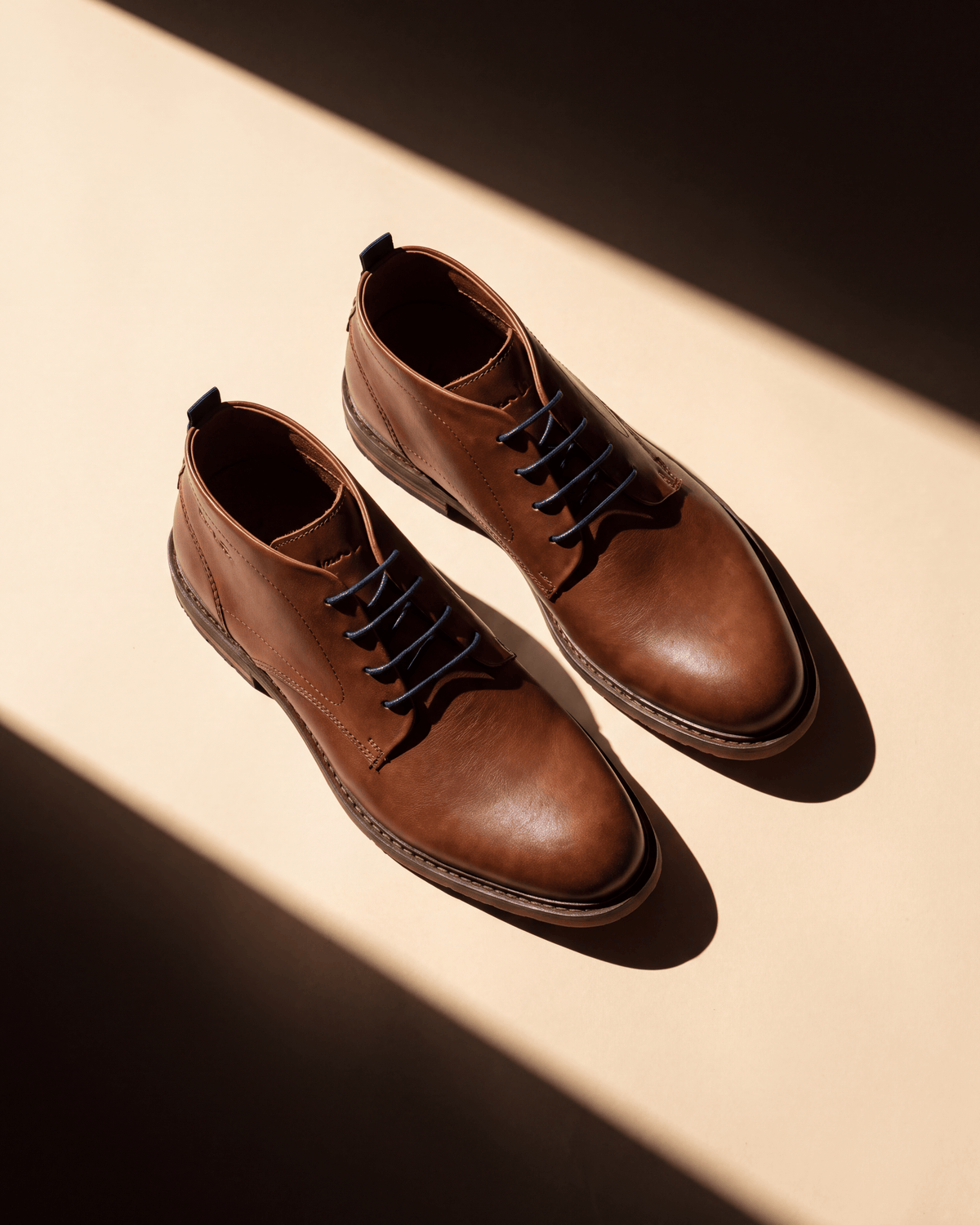 Cognac gladleren Dino Boot – het paar bij een raam met schaduw