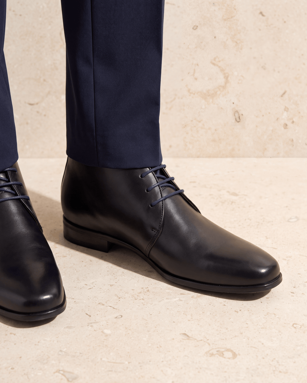 Zwart gladleren met rubberen zool Rhodes halfhoge veterschoen – close-up van het paar op kalksteen