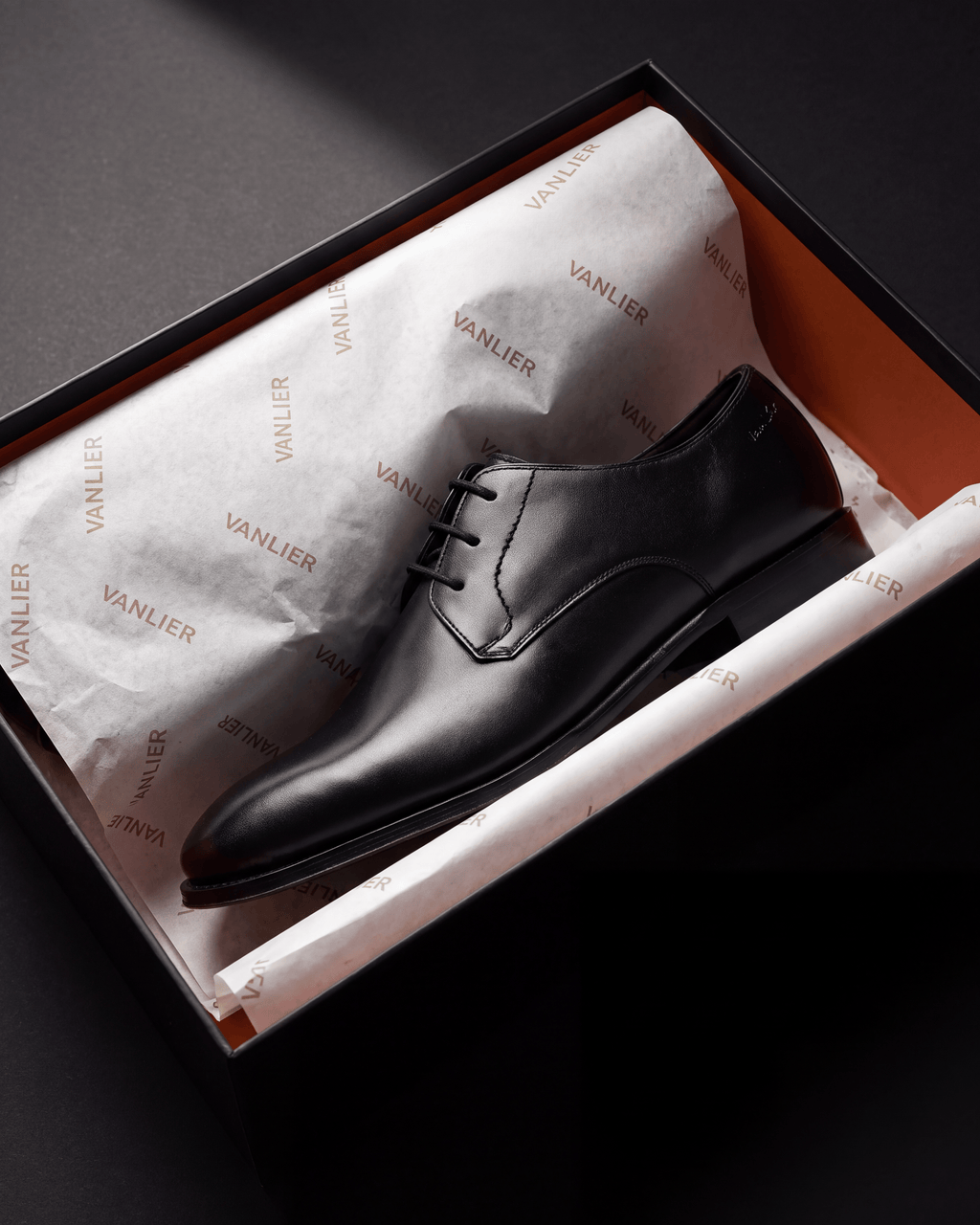 Zwart gladleren Madison veterschoen – het paar op een kalkstenen vloer