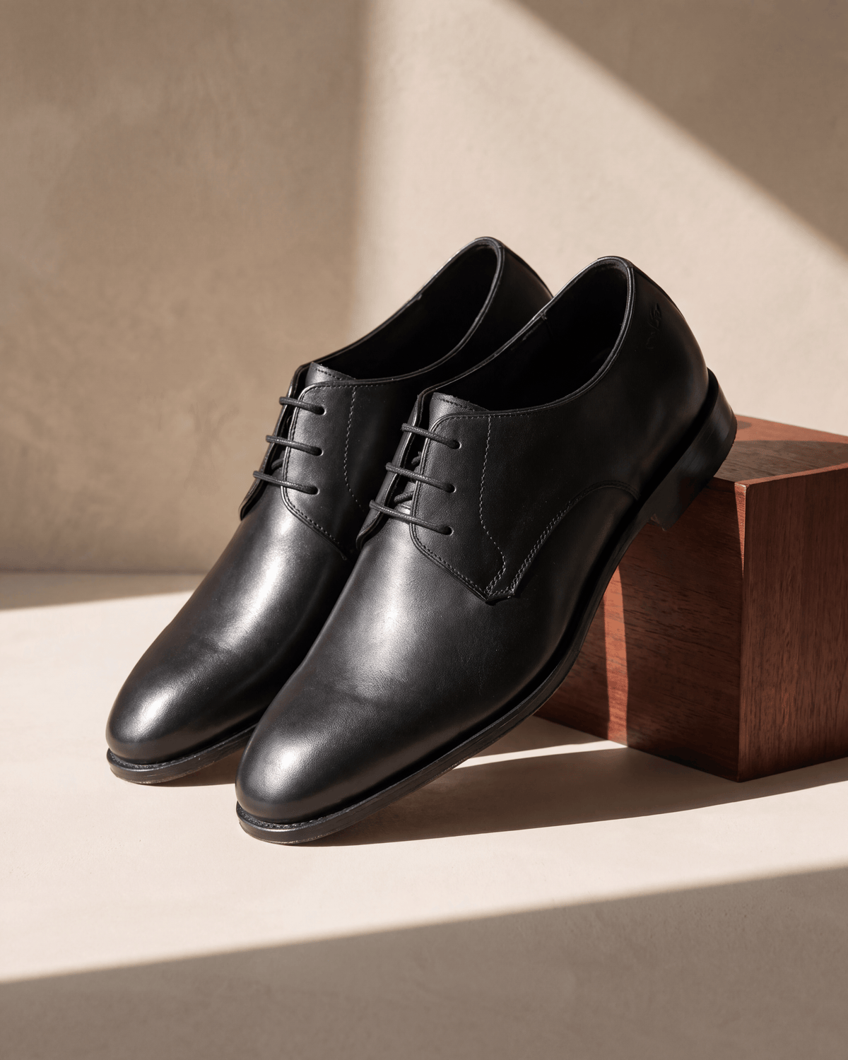Zwart gladleren Madison veterschoen – detail op hout en pleisterwerk, andere hoek