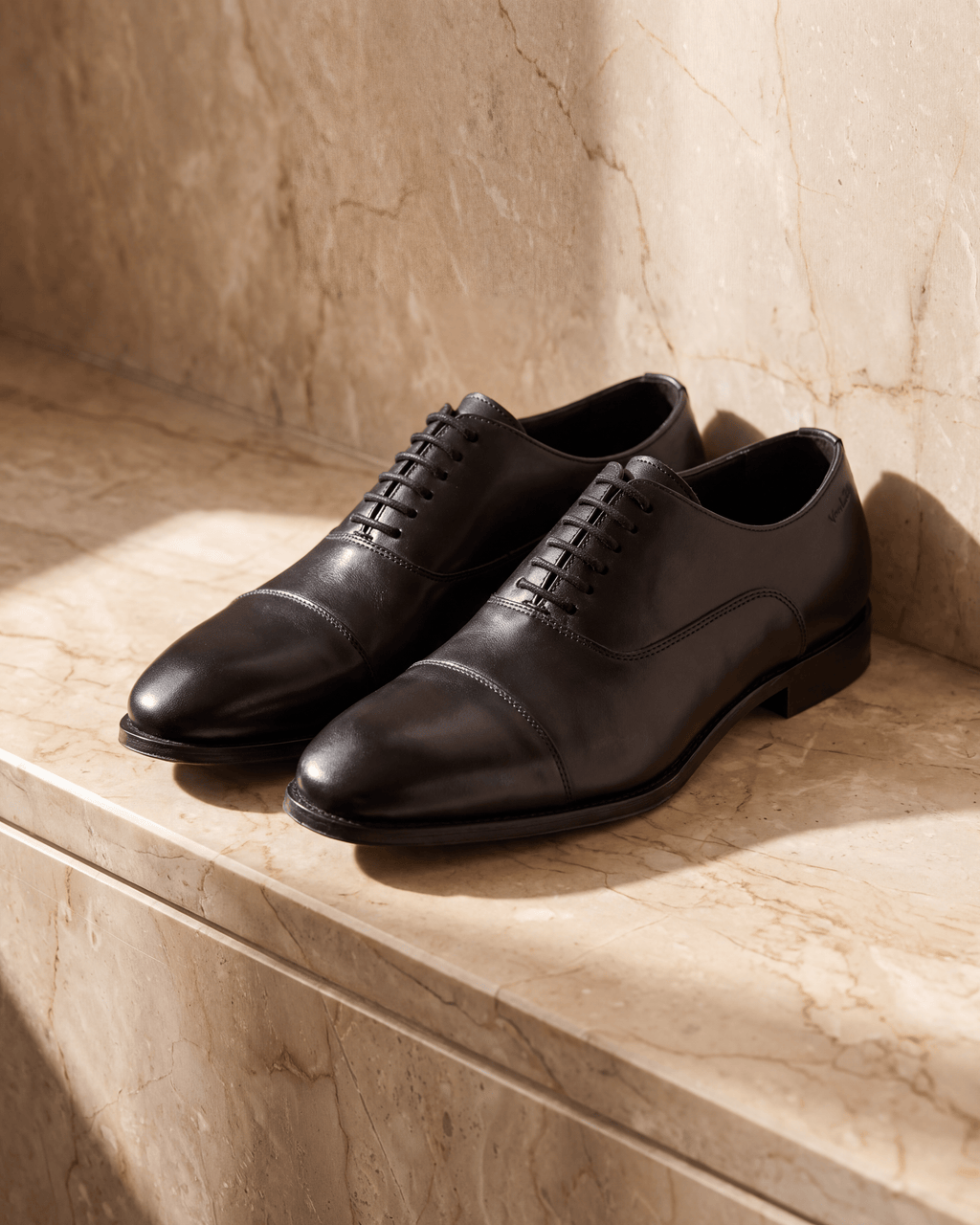 Zwart gladleren Madison veterschoen – het paar op warm marmer