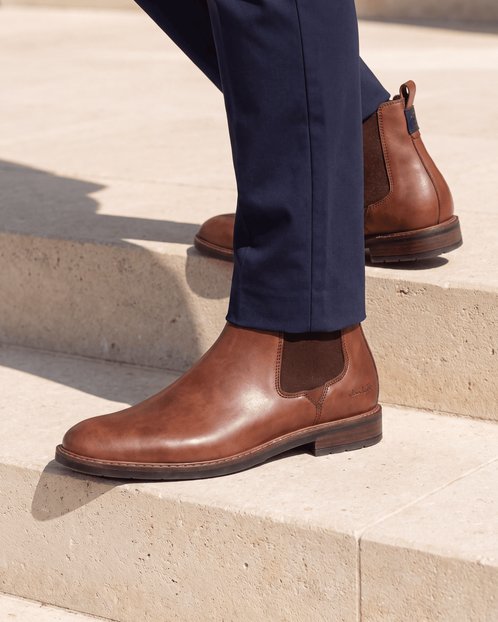 Cognac gladleren Boston chelsea boot – het paar op een kalkstenen vloer