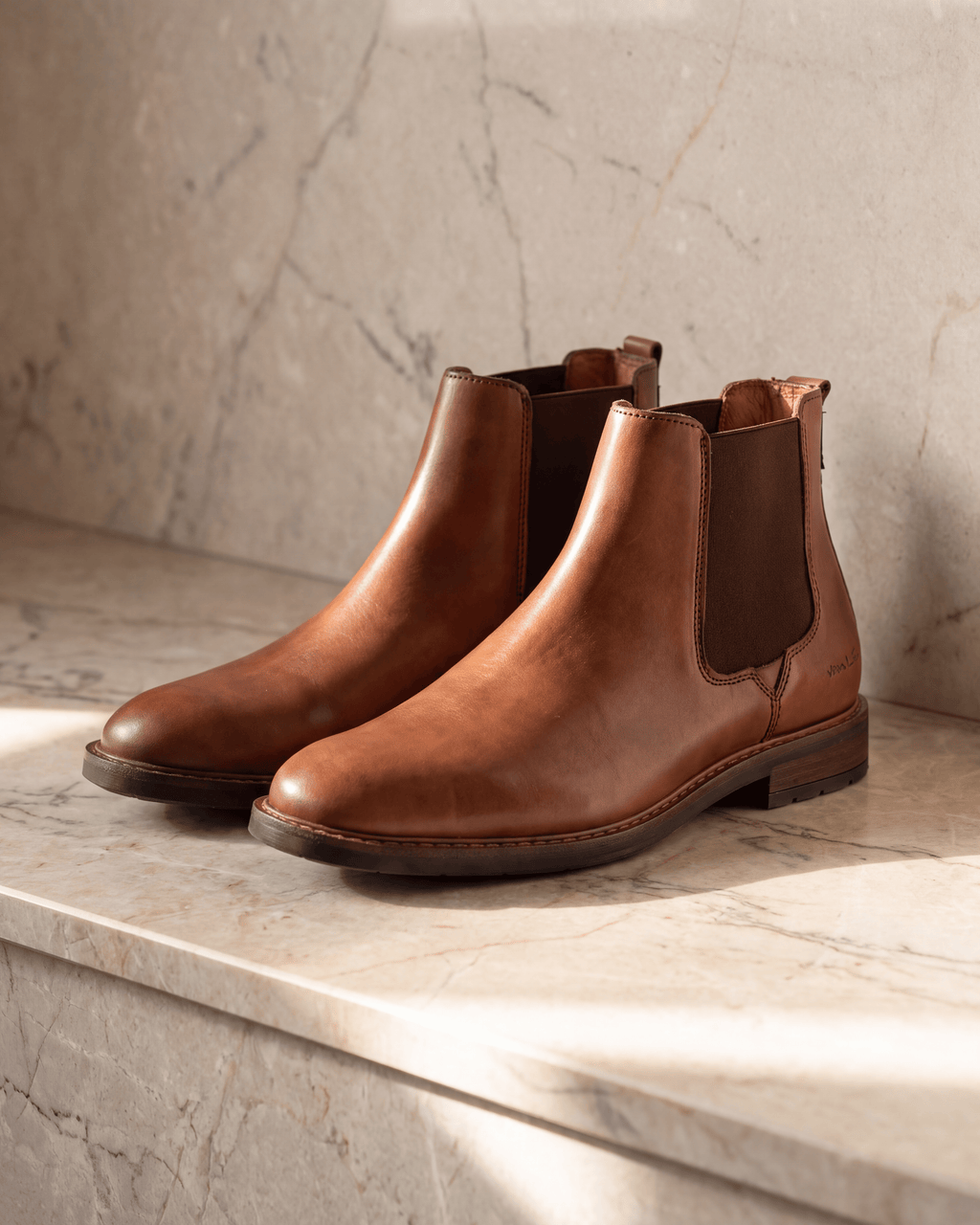 Cognac gladleren Boston chelsea boot – het paar op warm marmer