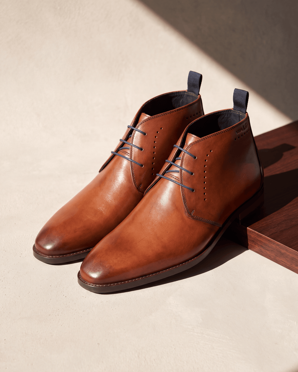 Cognac gladleren Bregenz halfhoge veterschoen – het paar op hout en pleisterwerk