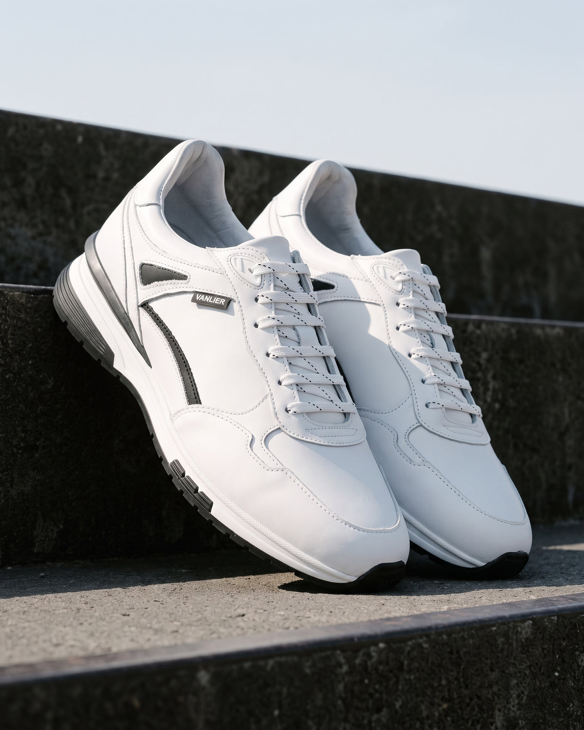 Wit gladleren Veneto sneaker – detail van het paar op ruw beton