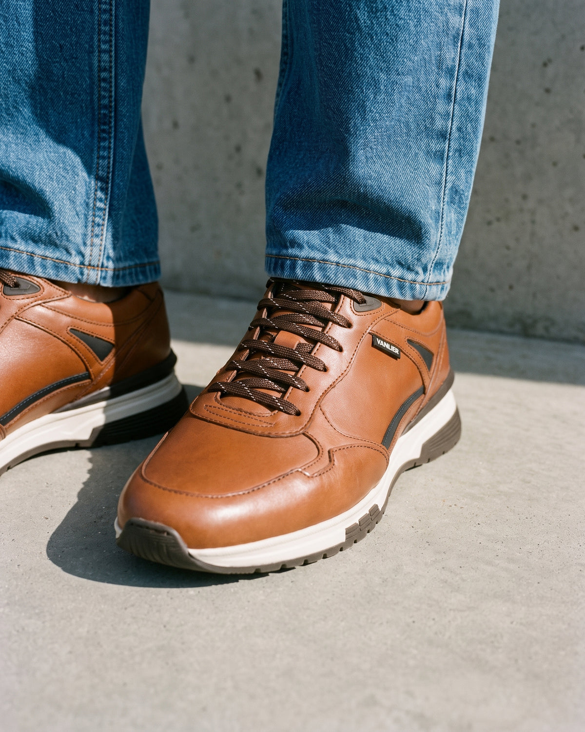 Cognac gladleren Veneto sneaker – close-up van het paar op een betonnen vloer, andere hoek