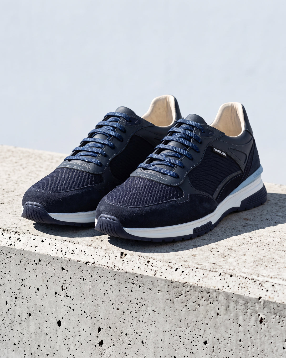 Blauw nubuck Veneto sneaker – close-up van het paar op ruw beton