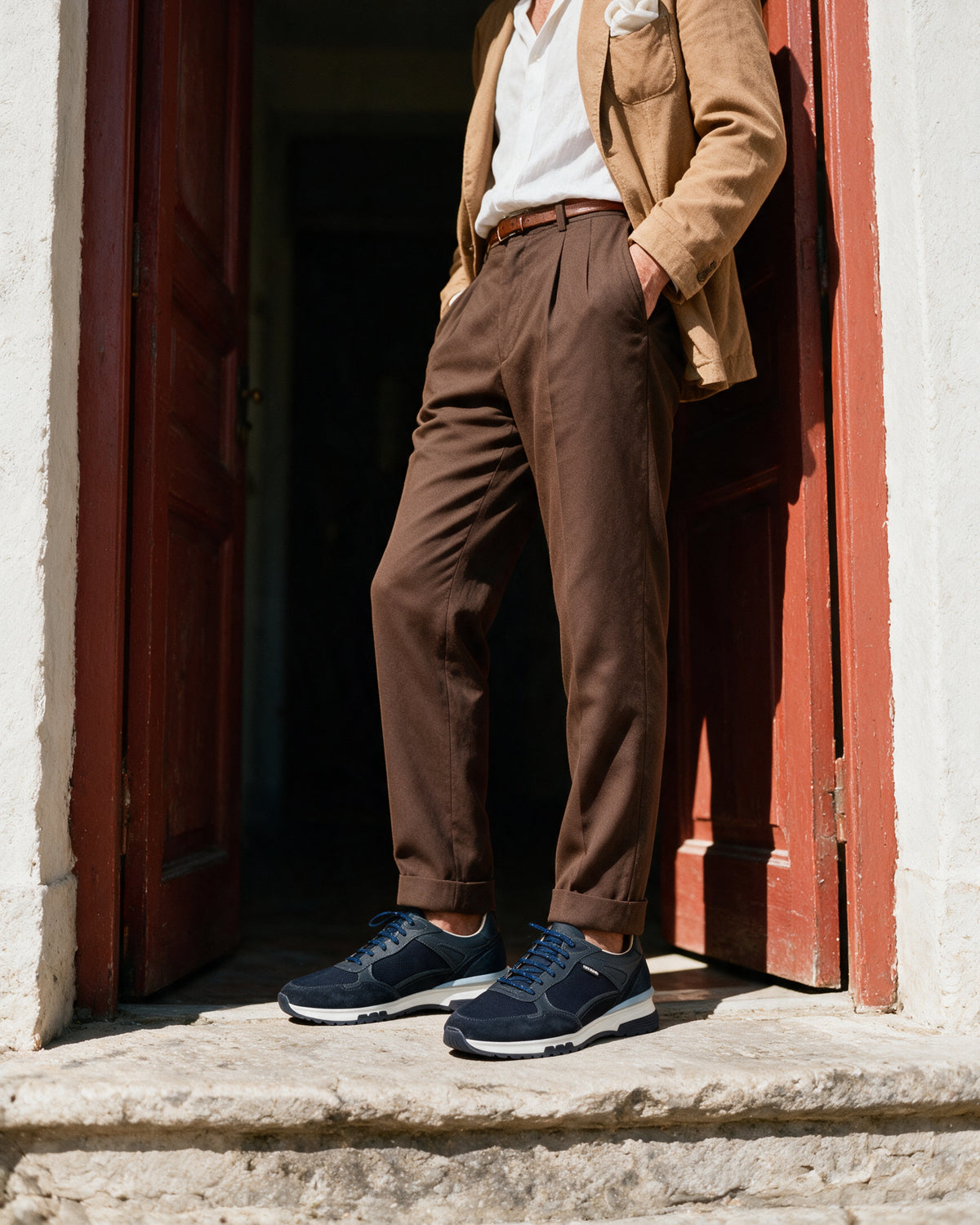 Blauw nubuck Veneto sneaker – gedragen bij een rode deur in een streep zonlicht