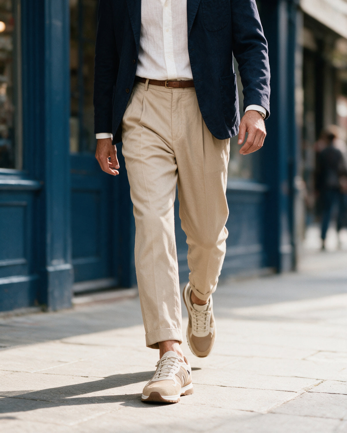 Taupe suède combi Veneto sneaker – gedragen, langs een blauwe winkelpui lopend