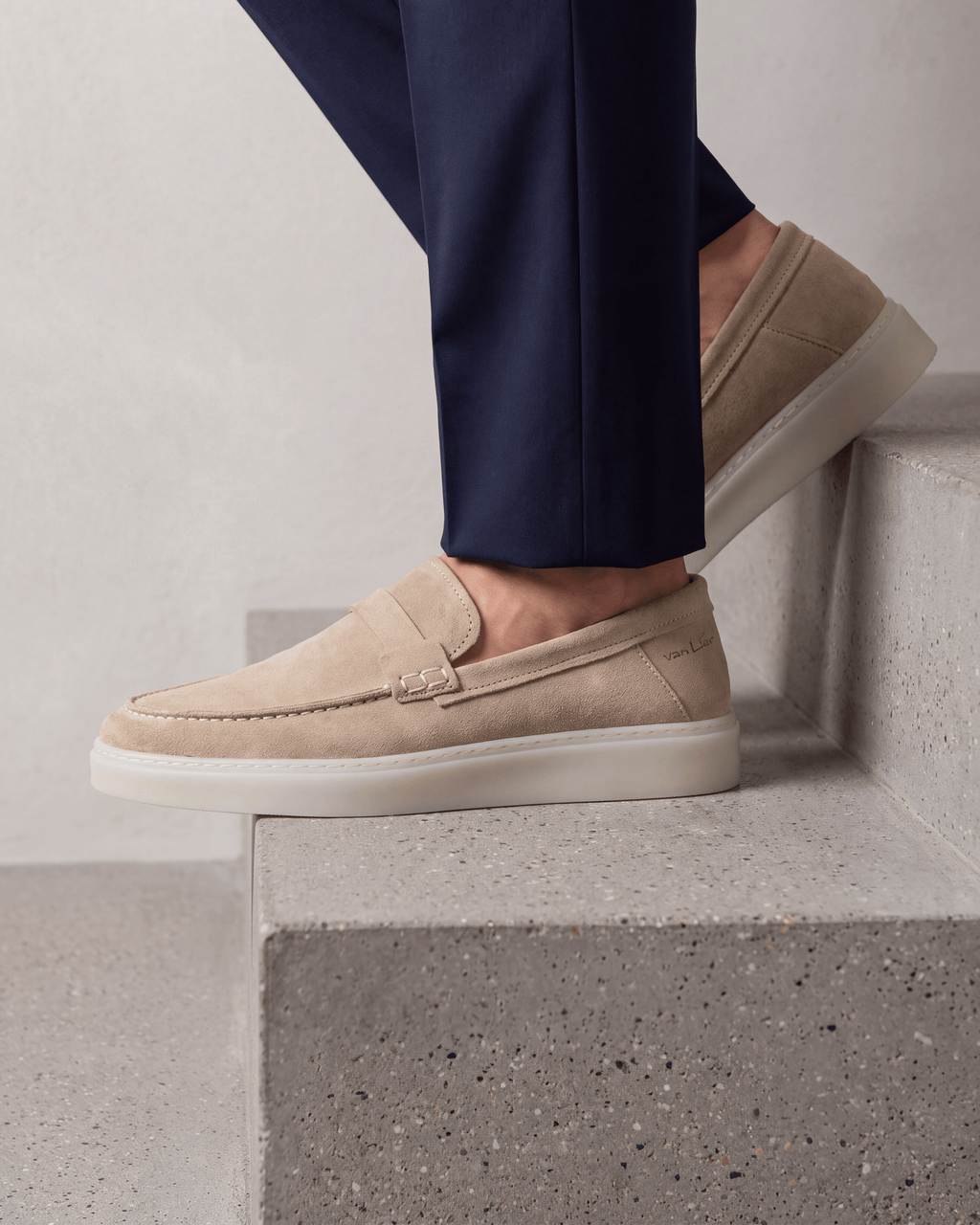 Beige suède Bari loafer – close-up van het paar op beton in een atelier