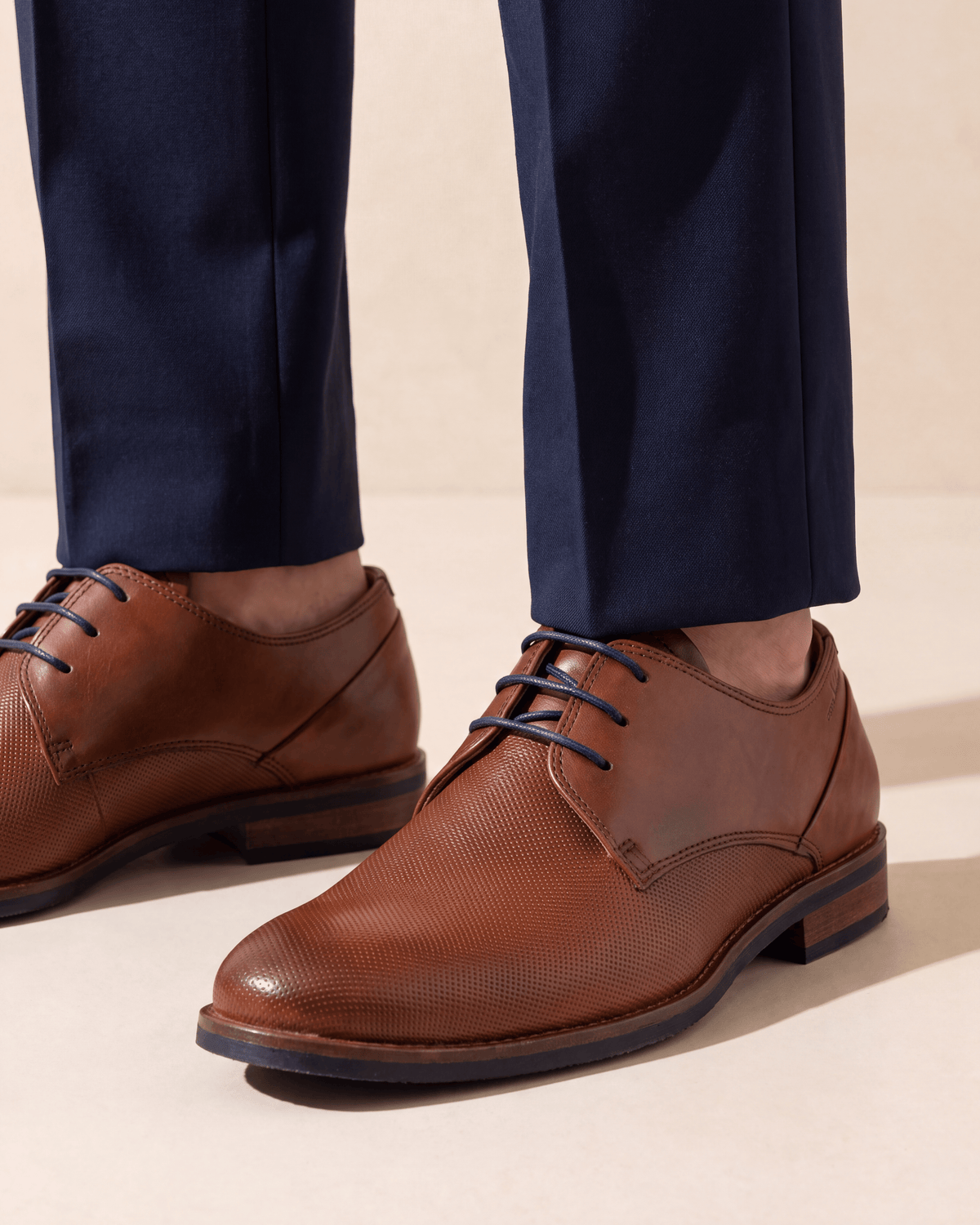 Licht cognac gladleren Sabinus veterschoen – close-up van het paar op kalksteen