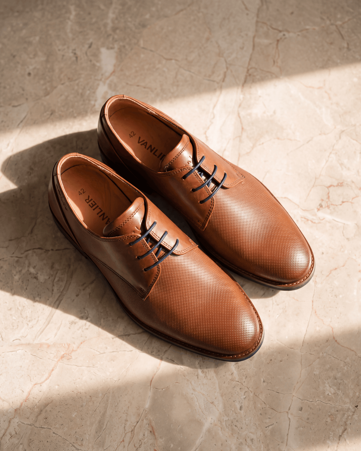 Licht cognac gladleren Sabinus veterschoen – detail op warm marmer