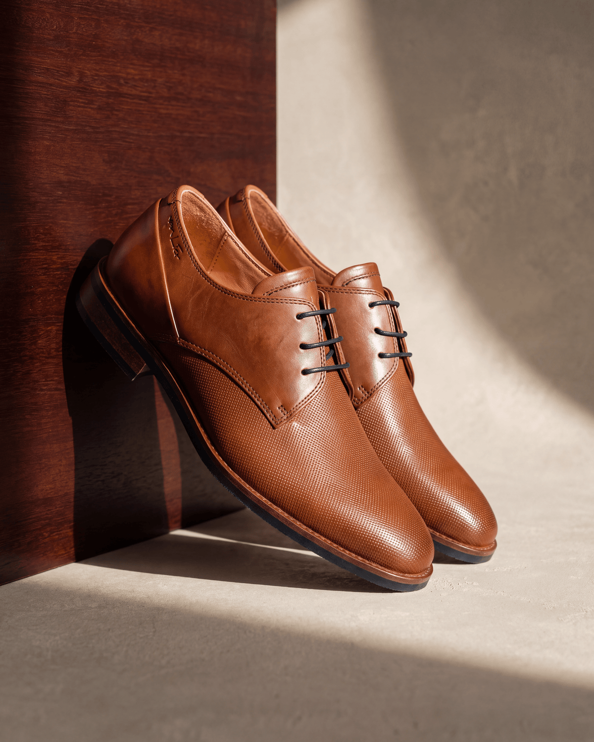 Licht cognac gladleren Sabinus veterschoen – detail op hout en pleisterwerk