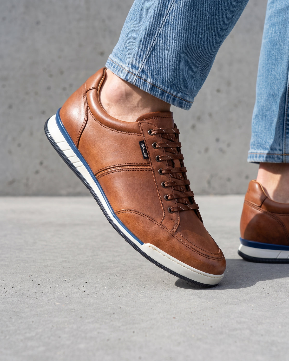Cognac gladleren Magnus sneaker – close-up van het paar op een betonnen vloer
