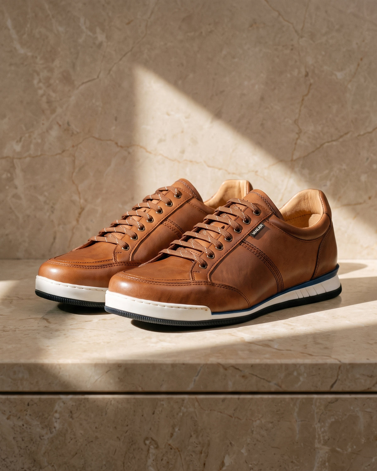 Cognac gladleren Magnus sneaker – close-up van het paar op marmer