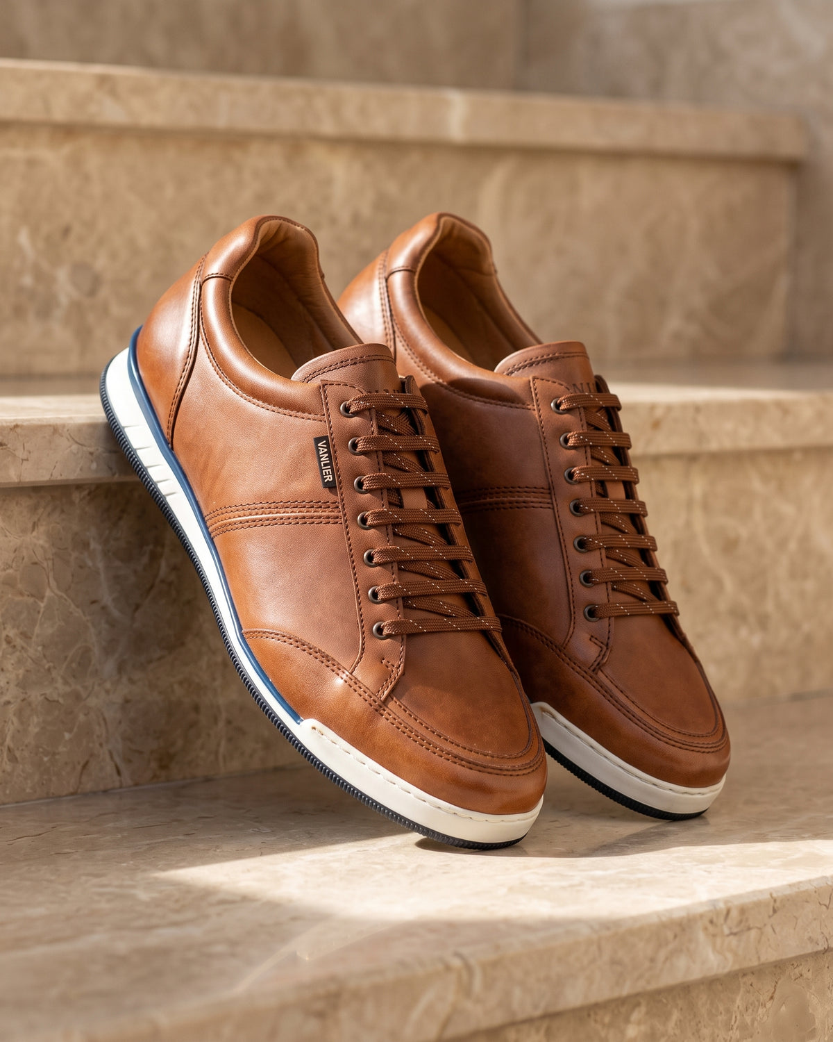 Cognac gladleren Magnus sneaker – detail van het paar op marmer