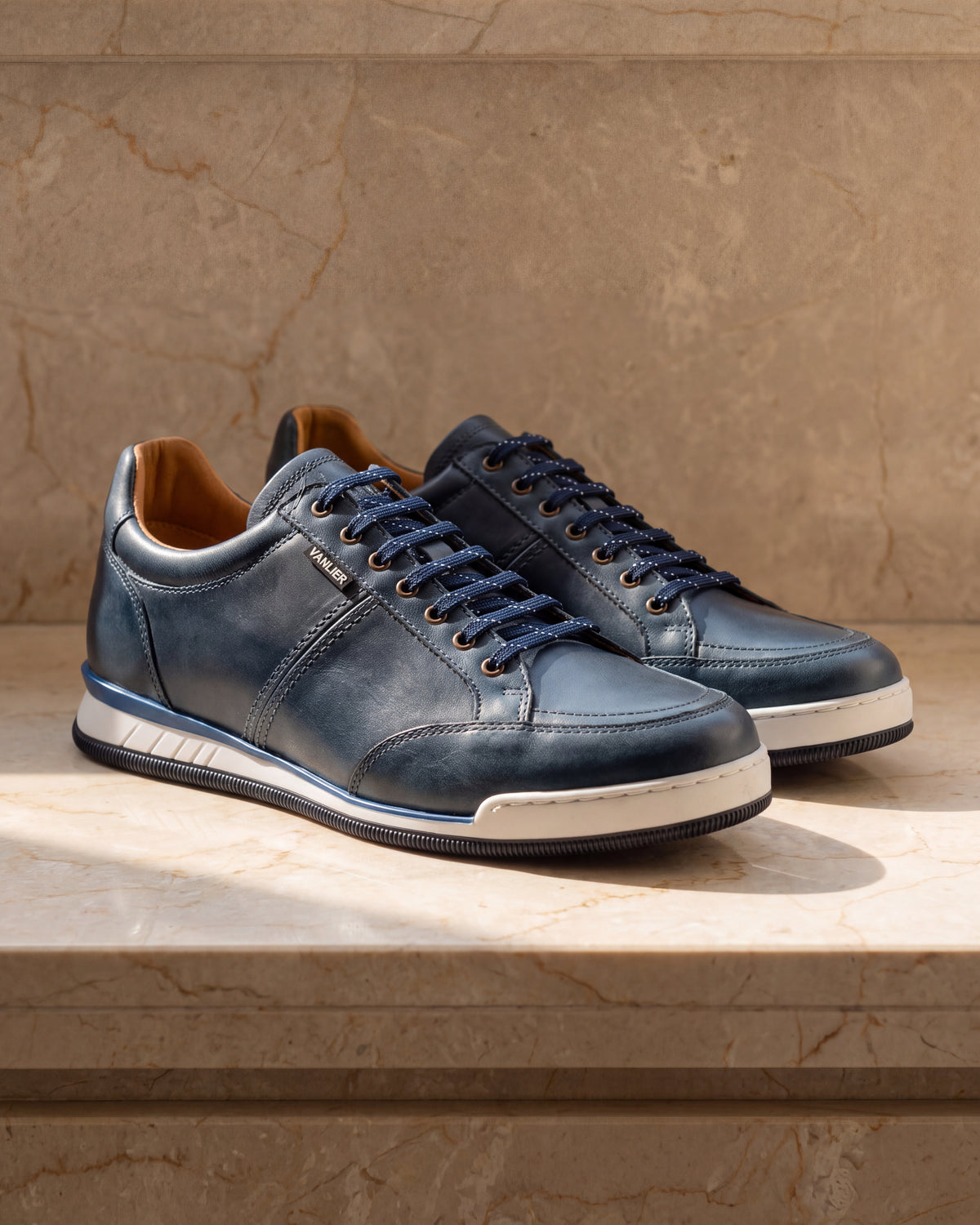 Blauw gladleren Magnus sneaker – close-up van het paar op marmer