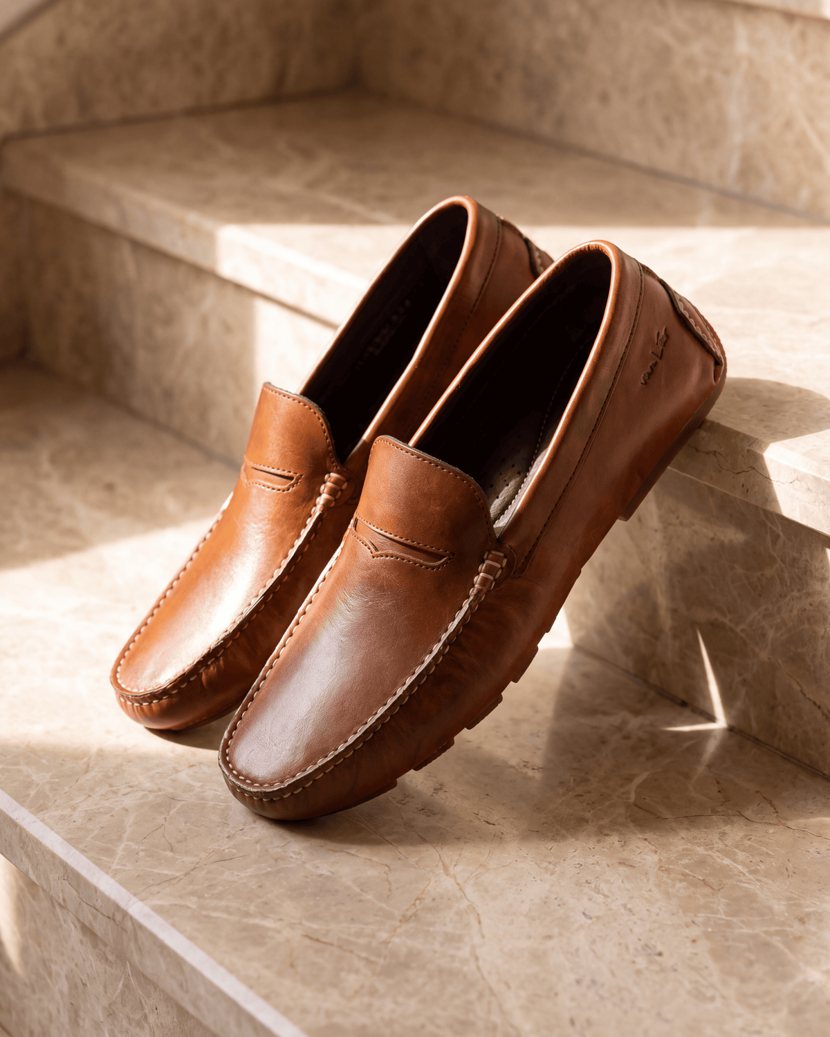 Cognac volnerf leren Mocassin – stilleven op warm marmer