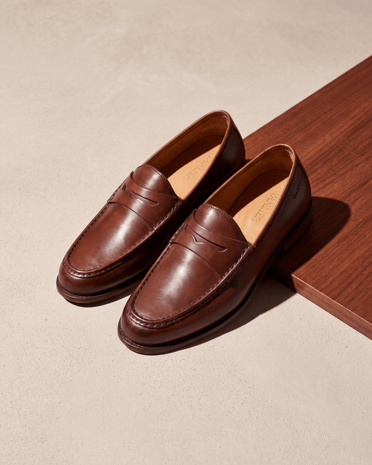 Cognac gladleren Cambridge Penny loafer – stilleven op hout en pleisterwerk