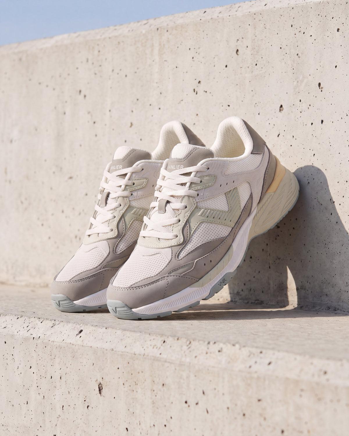 Wit lichtgroen combi Cosmos sneaker – close-up van het paar op ruw beton