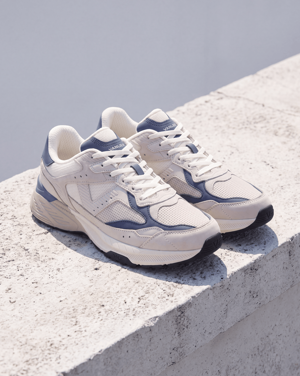 Wit lichtblauw combi Cosmos sneaker – close-up van het paar op een betonnen trede