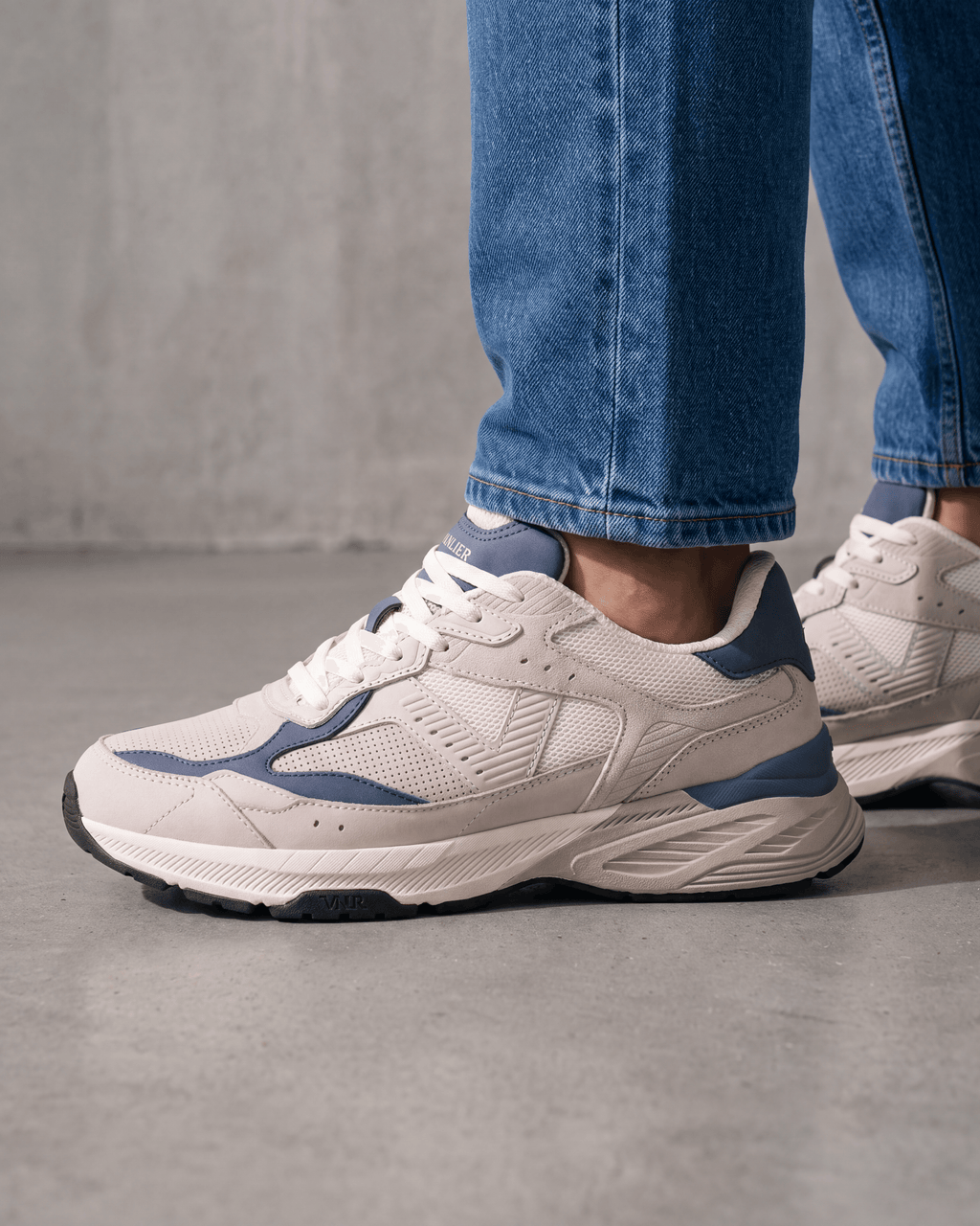 Wit lichtblauw combi Cosmos sneaker – gedragen, zijaanzicht op beton