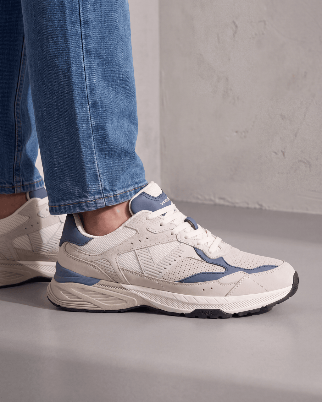 Wit lichtblauw combi Cosmos sneaker – gedragen, driekwart aanzicht op beton