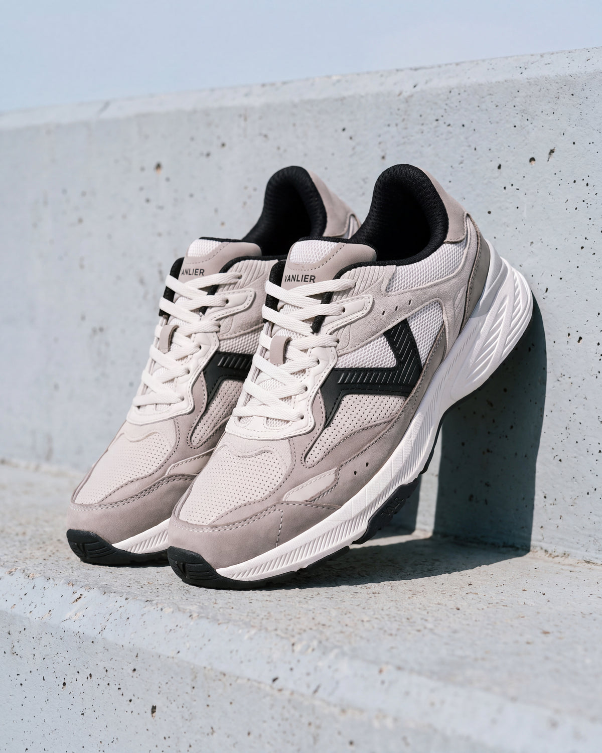 Wit zwart combi Cosmos sneaker – close-up van het paar op ruw beton