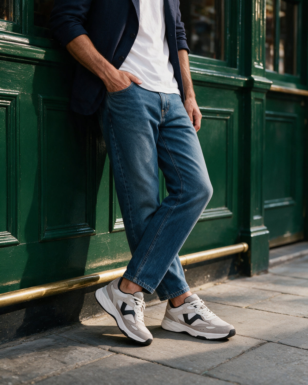 Wit zwart combi Cosmos sneaker – gedragen, leunend tegen een winkelpui